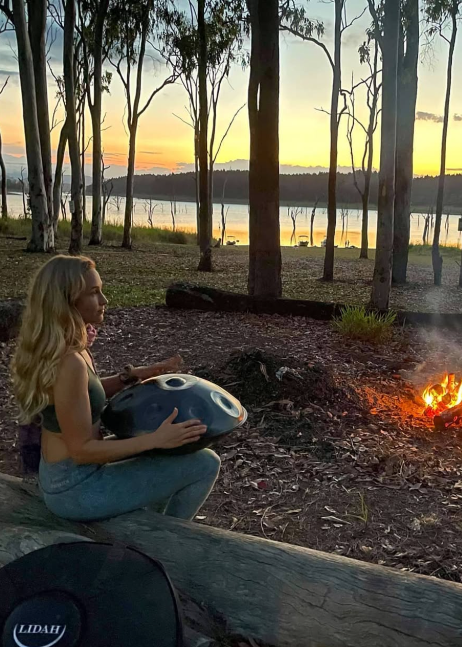 Women Sitting outside with LIDAH Handpan on her lap as the sun sets